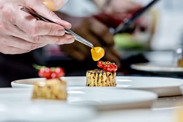 Memoria laptelui Chef Silviu așază roșii confiate pe un cilindru de porumb copt, într-un plating minimalist