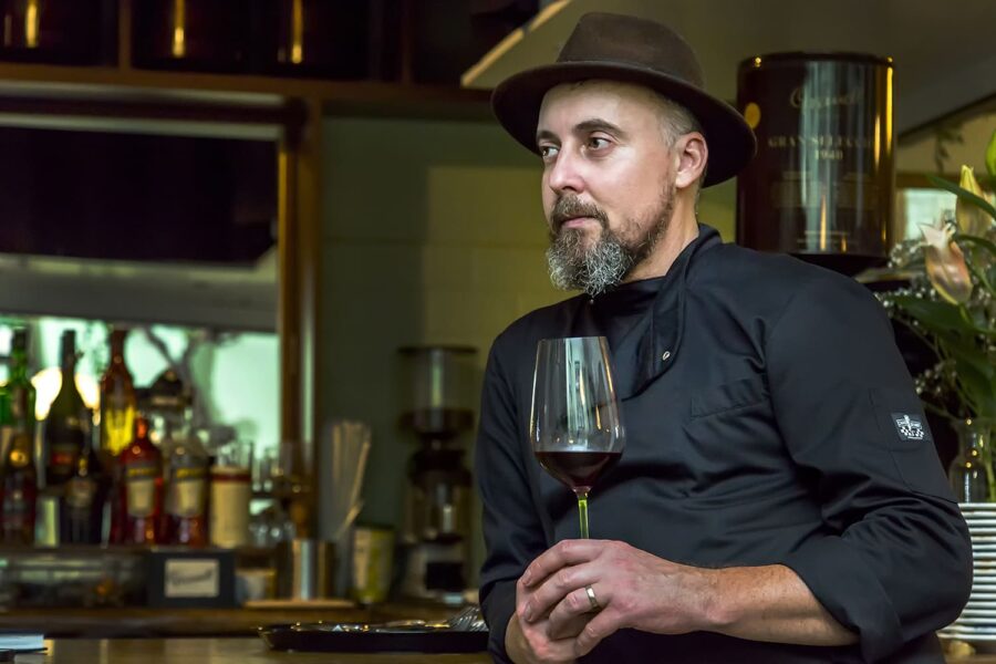 Chef Silviu Atanasie reflectând la finalul unei zile de lucru, cu un pahar de vin în mână – simbol al echilibrului dintre tradiție și curaj.